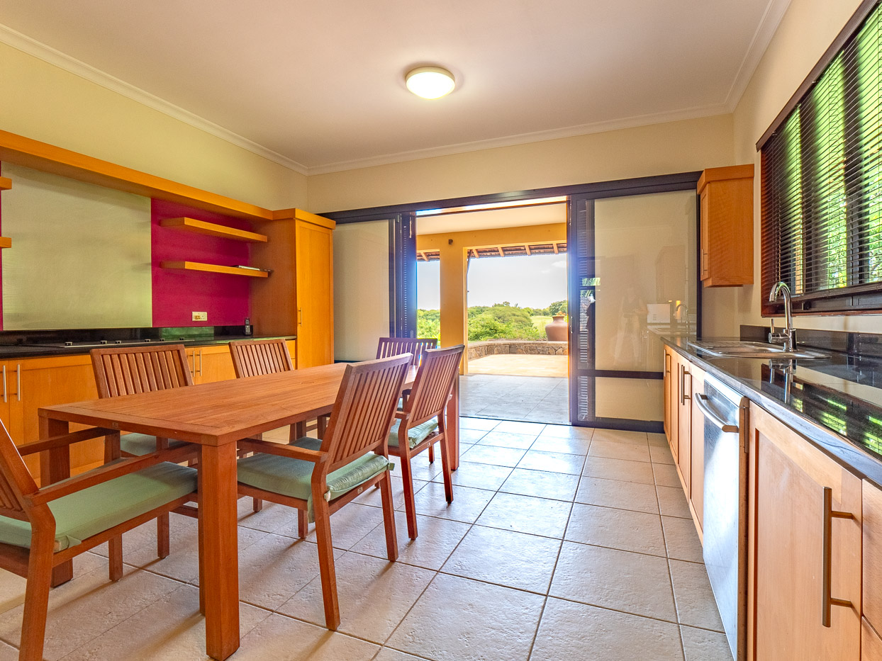 Modern kitchen and stylish dining area in a Tamarina villa by Ohana Heritage Group