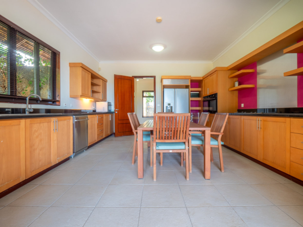 Modern kitchen and stylish dining area in a Tamarina villa by Ohana Heritage Group