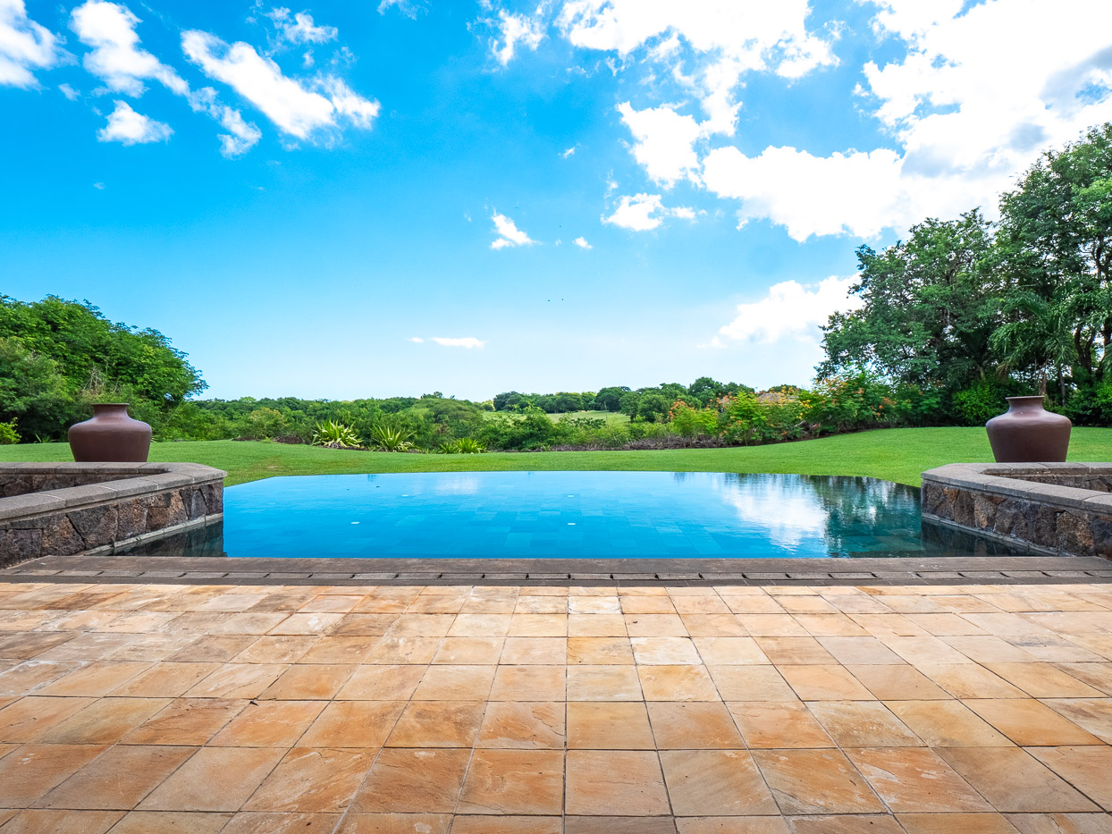 Jardin luxuriant avec piscine et vue sur le golf de Tamarina, Ohana Heritage Group